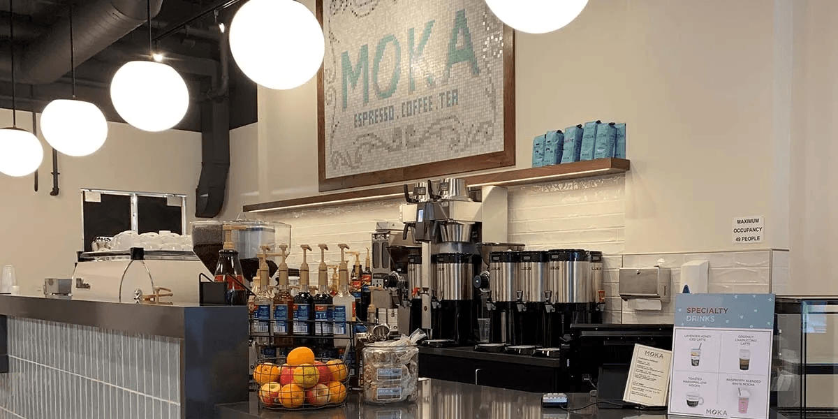 Moka coffee bar with espresso machines and mosaic sign
