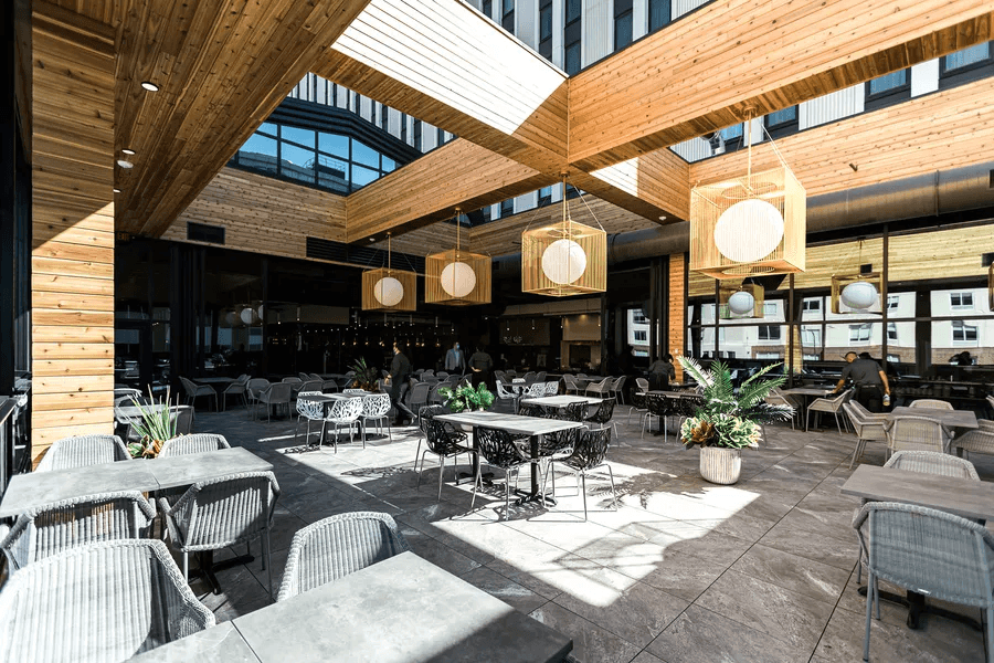 Crave bright covered patio with wood beams and globe lights