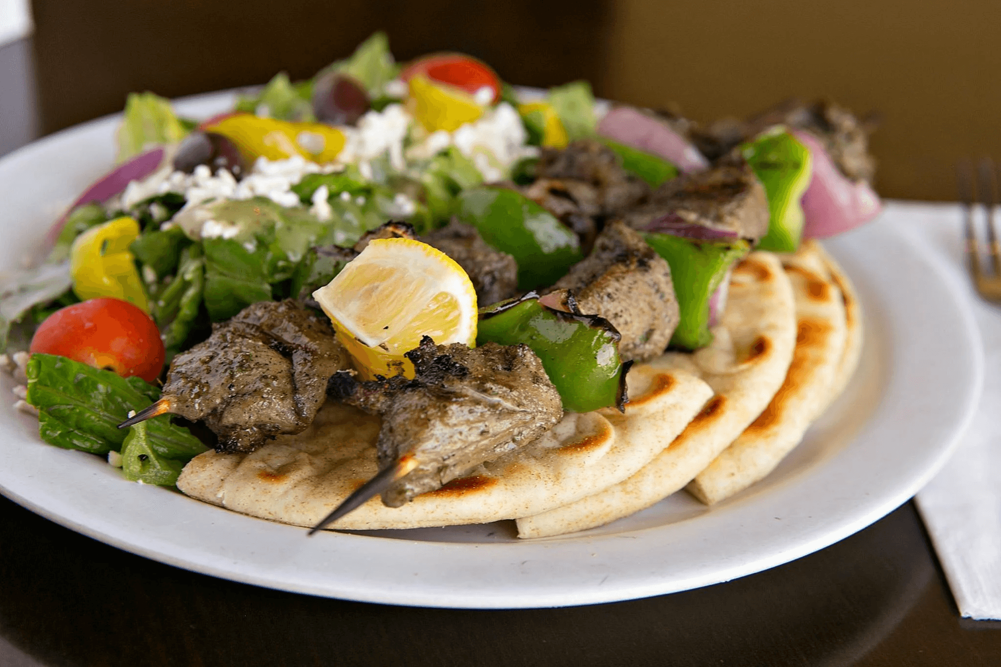 Grilled lamb skewers and Greek salad on pita at Nupa