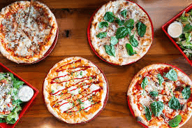 Spread of wood-fired thin crust pizzas at Pi Pizza